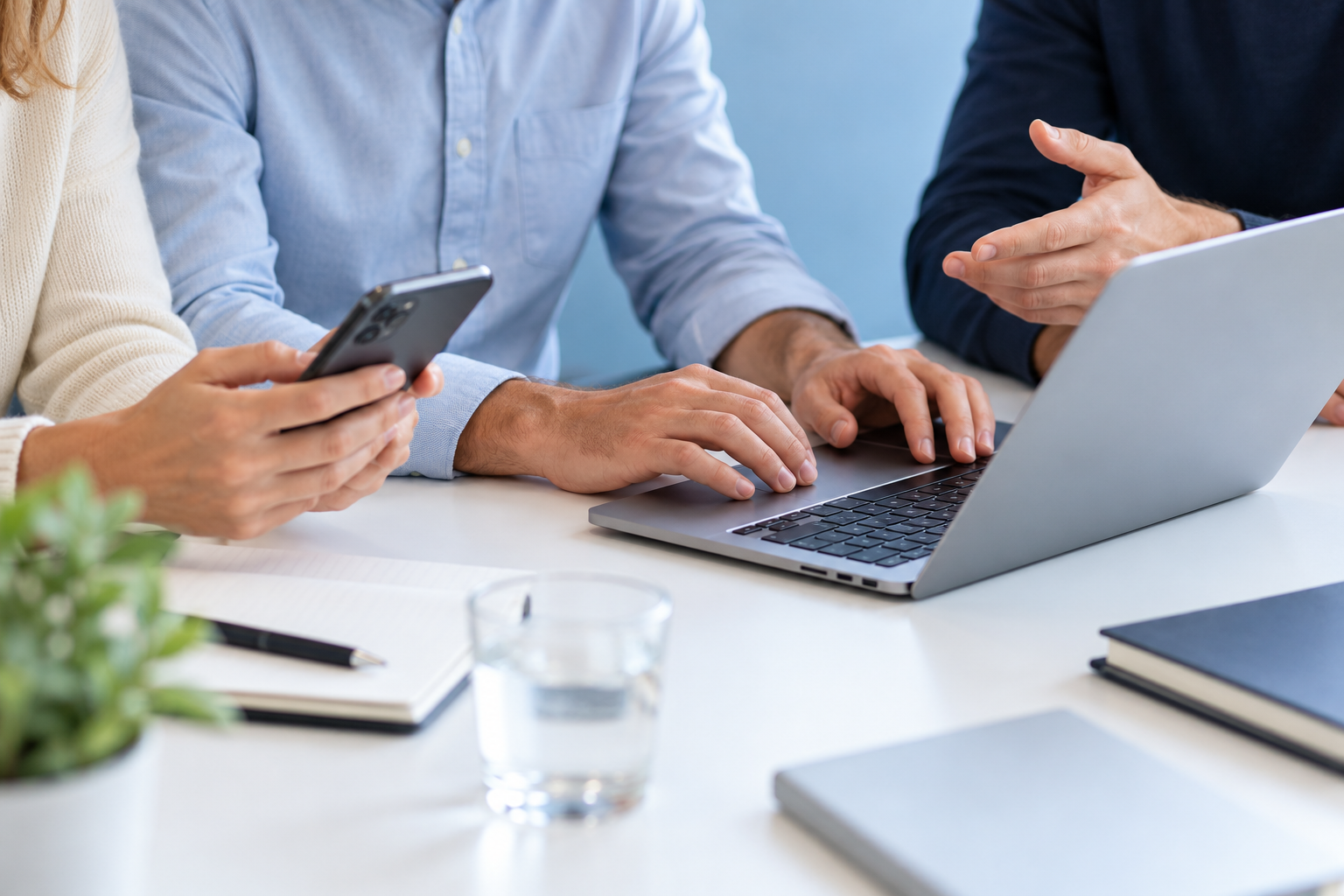 Symbolbild: Menschen arbeiten gemeinsam mit Laptop und Smartphone.